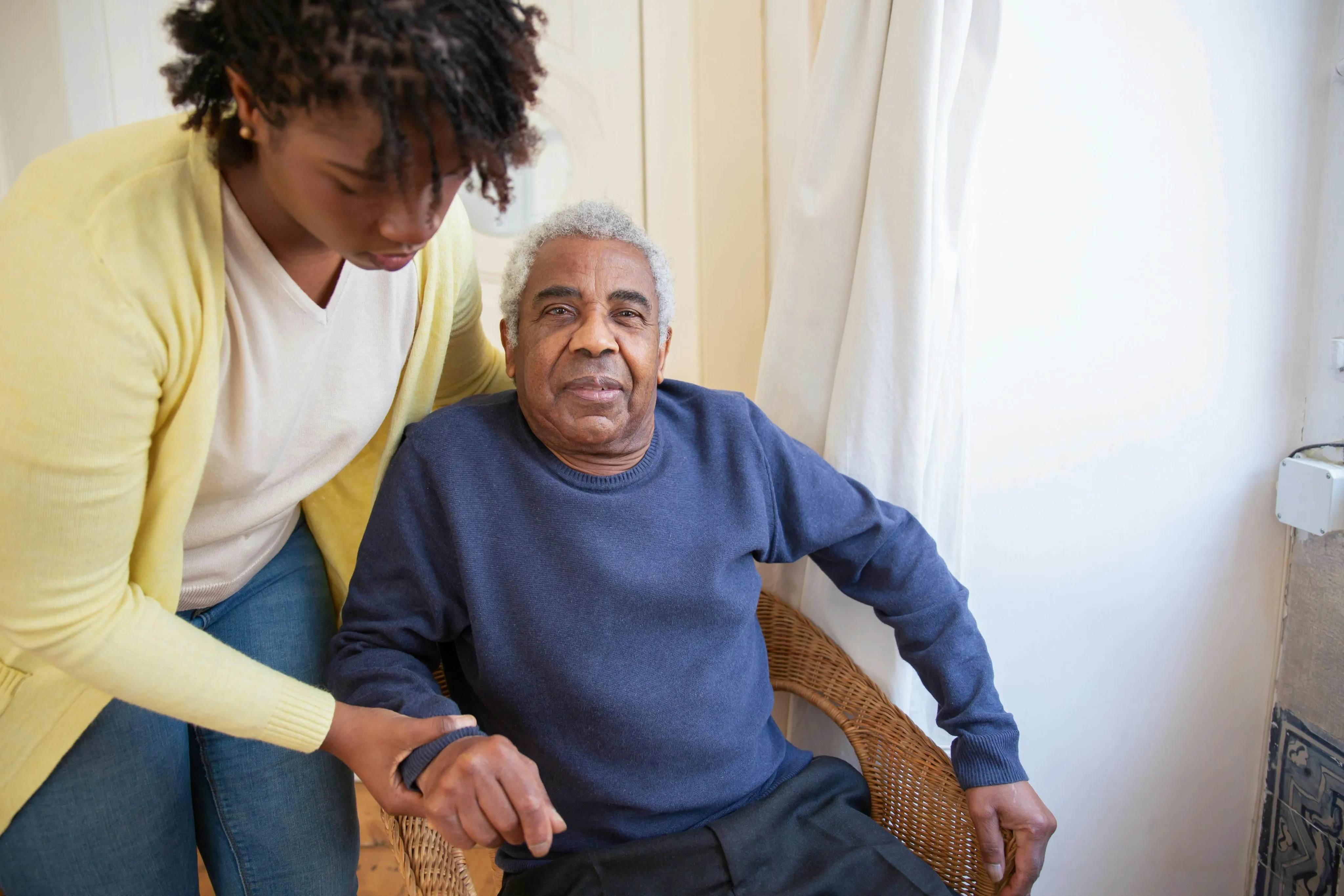 A caregiver sitting with an older family member at home