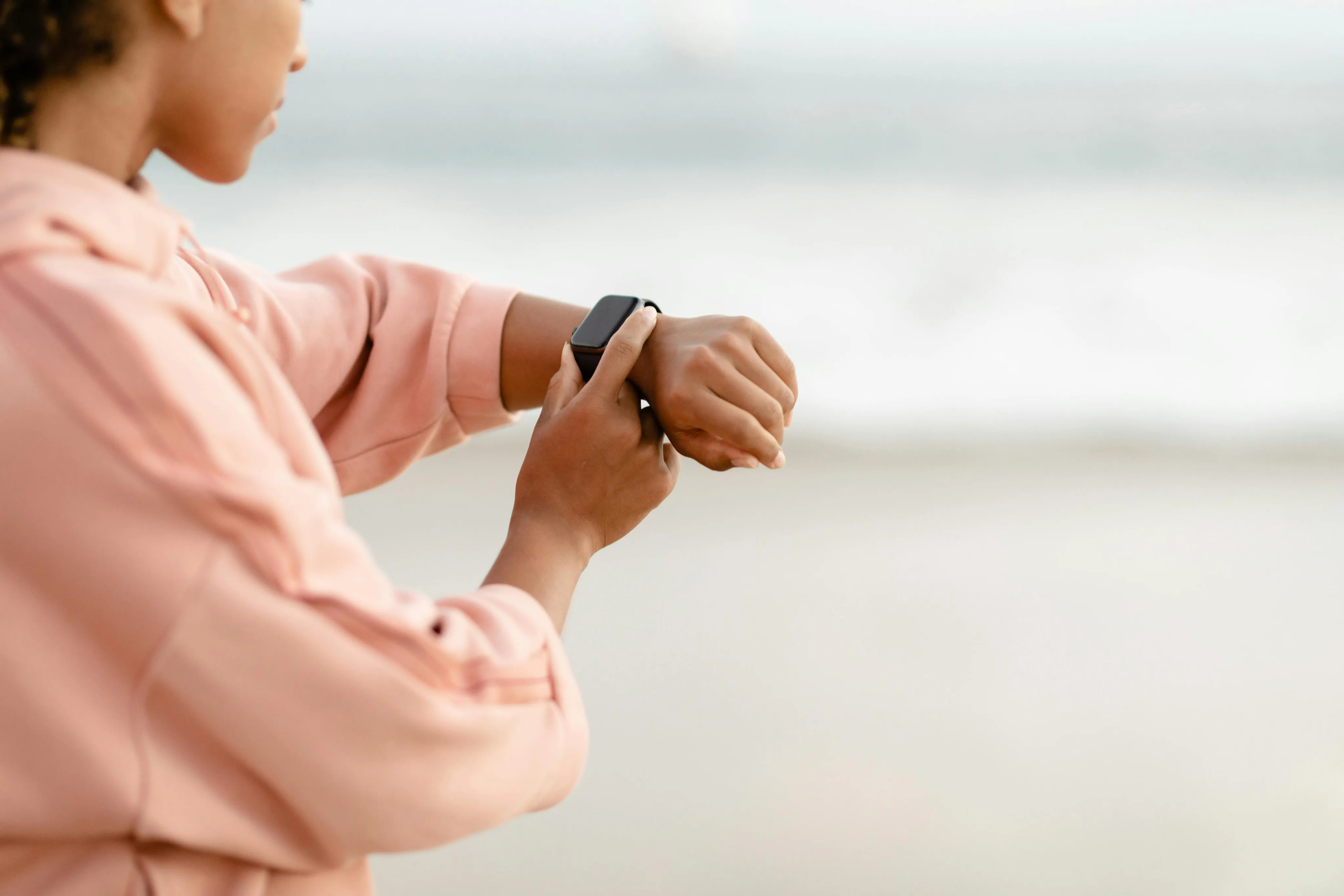 A woman checking a smartwatch outdoors