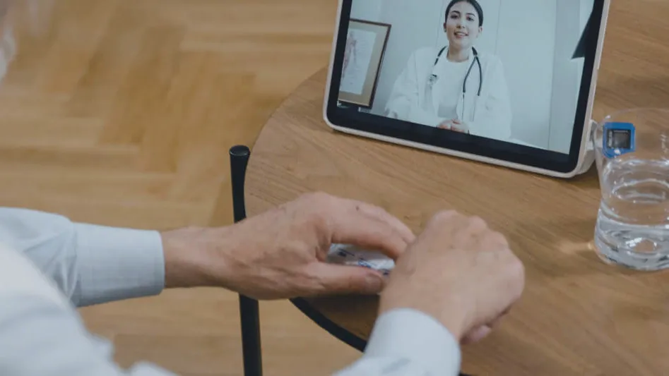 A tablet on a table showing a video call with a clinician