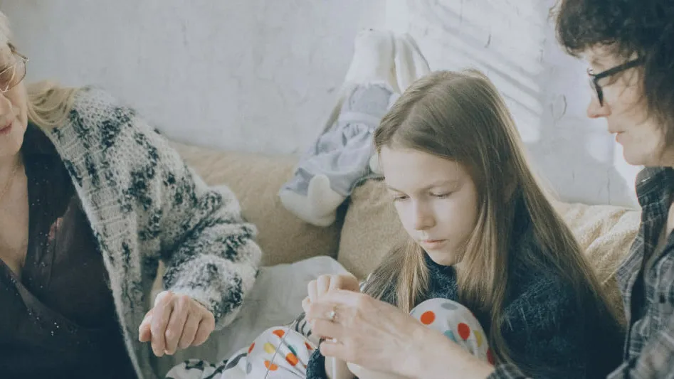 A grandmother, mother and daughter together on a sofa